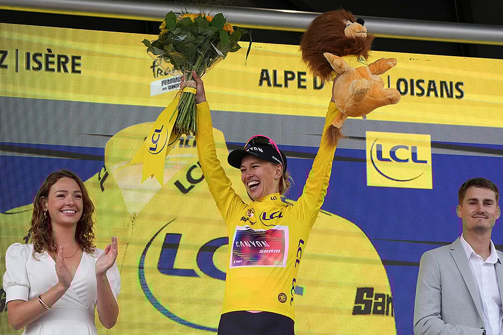 | Photo: AP/Peter Dejong : Tour de France Women cycling race: Winner Katarzyna Niewiadoma of Poland, wearing the overall leader's yellow jersey celebrates on the podium after the eighth stage